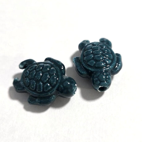 Two blue turtle-shaped beads on a white background