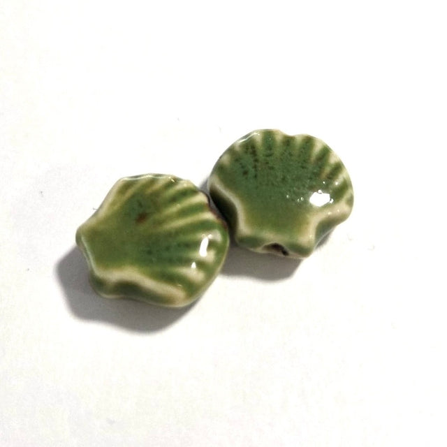 Two green ceramic beads on a white background