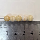 cream and beige round glass beads with a ruler for scale