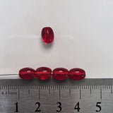 Red beads on a white background with a ruler for scale