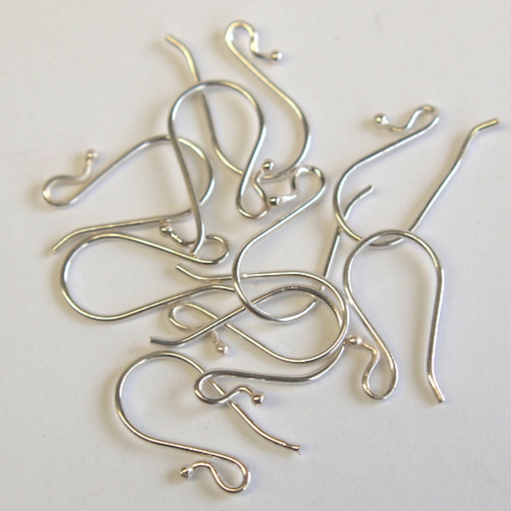 A pile of silver-sterling 925 ear wires with ball endings on a white background.