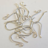A pile of silver-sterling 925 ear wires with ball endings on a white background.