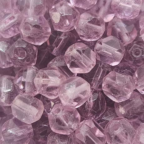 a collection of purple cut glass beads showing the shape of the cuts and the threading holes