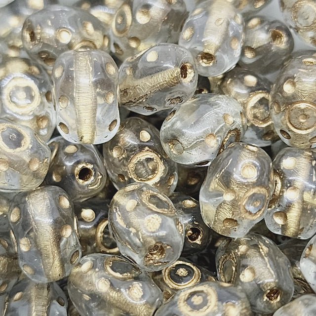 A close-up image of small, clear oval-shaped Czech glass beads with gold accents.