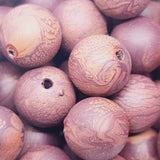 Close-up of marble finish wood look beads with a central hole.