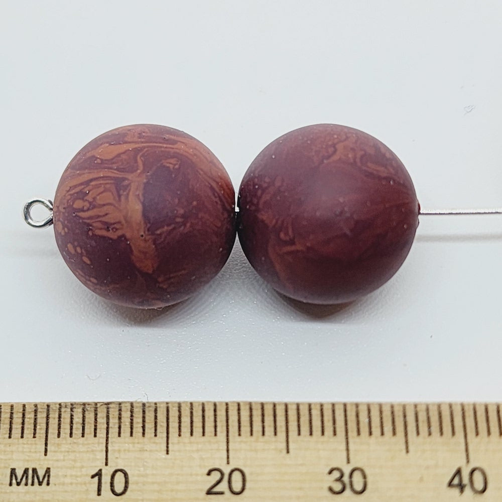 Close-up of marble finish wood look beads with a central hole.