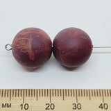Close-up of marble finish wood look beads with a central hole.