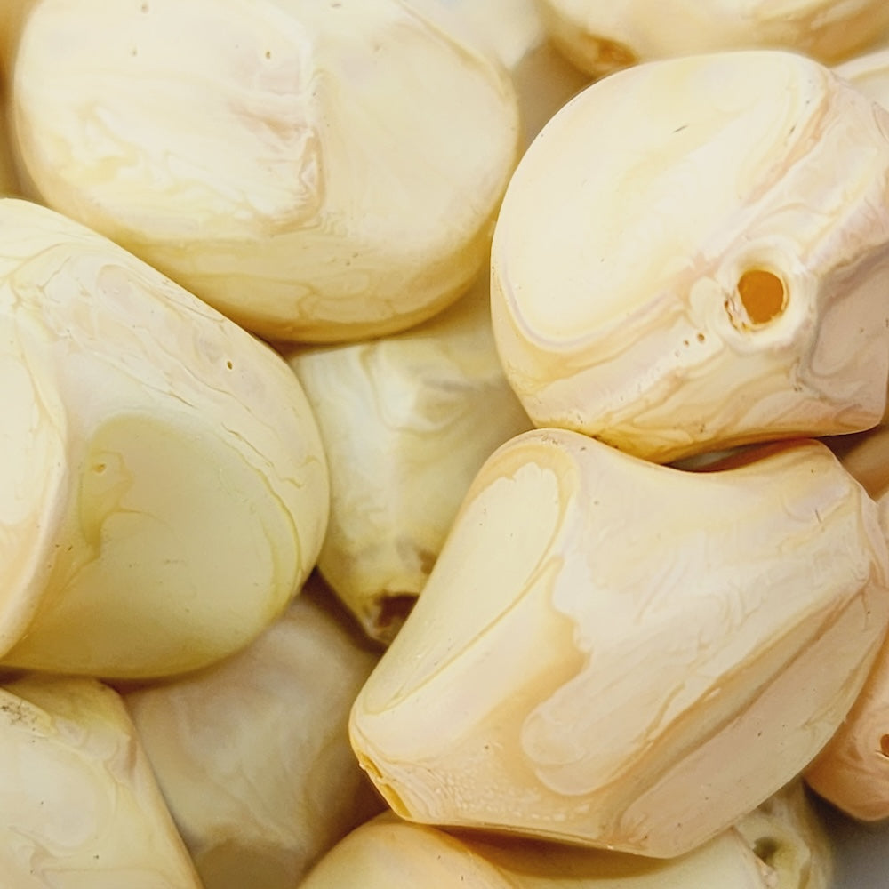 Close-up of beige wood look beads with a central hole.
