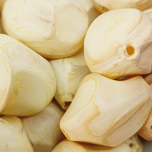 Close-up of beige wood look beads with a central hole.
