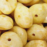 Close-up of yellow marbled beads with holes