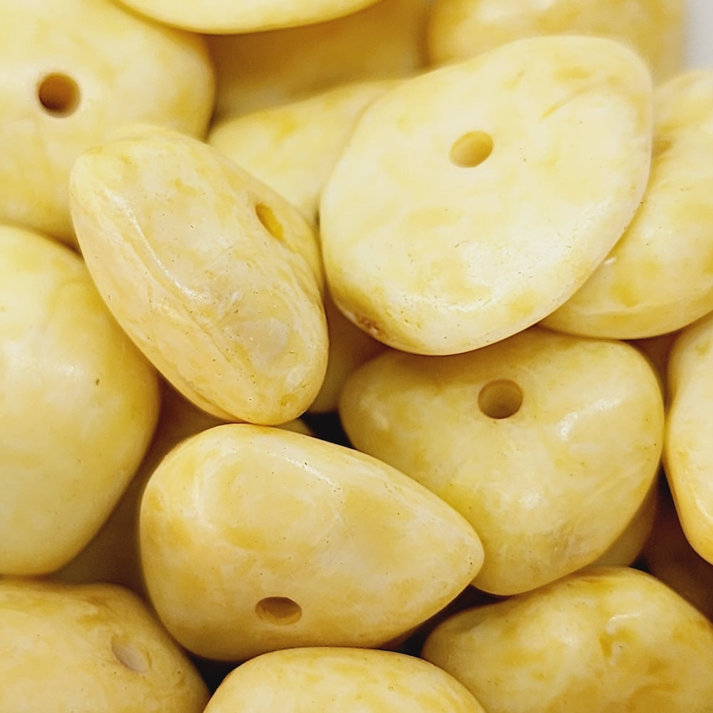 Close-up of yellow stone look bakelite beads with holes, for beading jewellery