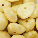 Close-up of yellow stone look bakelite beads with holes, for beading jewellery