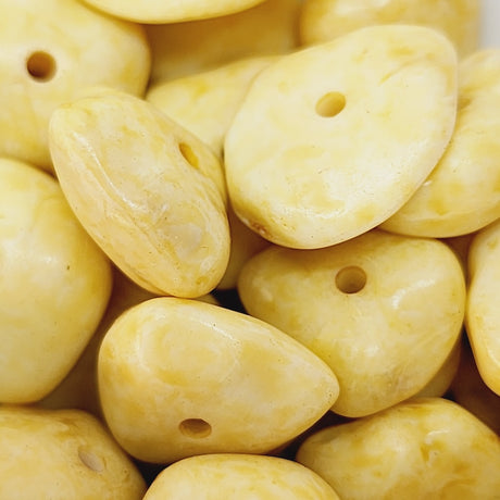 Close-up of yellow stone look bakelite beads with holes, for beading jewellery