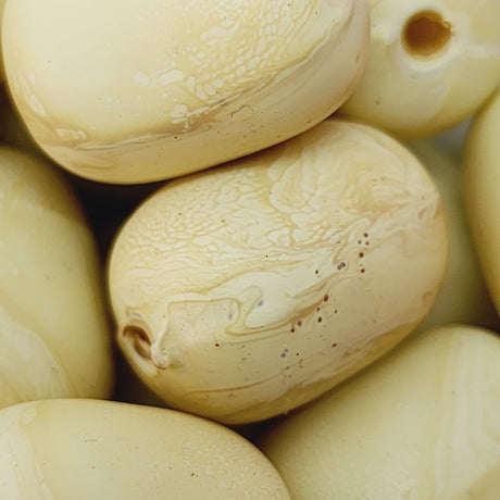 Close-up of beige wood look beads with a central hole.