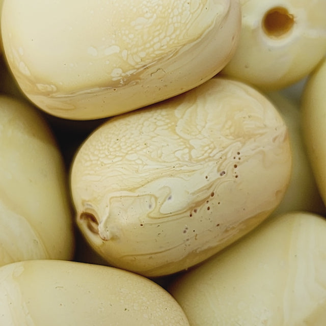 Close-up of beige wood look beads with a central hole.