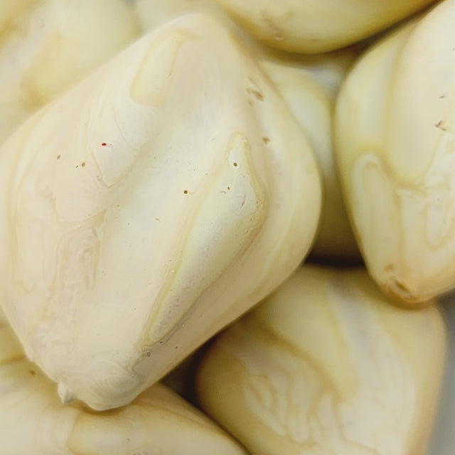Close-up of marble finish wood look beads with a central hole.