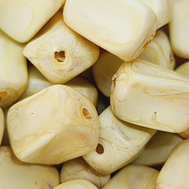 Close-up of marble finish wood look beads with a central hole.