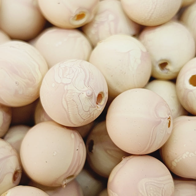 Close-up of marble finish wood look beads with a central hole.