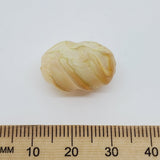 Marbled bead with a ruler for scale on a white background