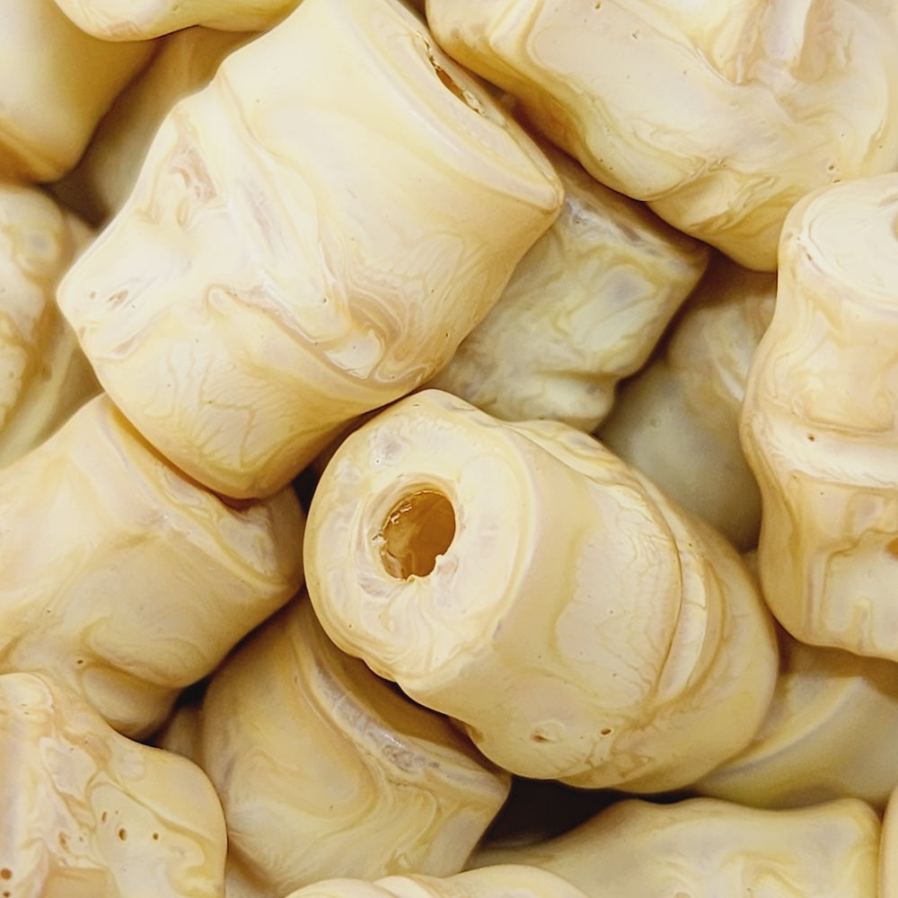 Close-up of marble finish wood look beads with a central hole.