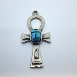 Metal Ankh vintage charm with turquoise blue tiny scarab beetle in the centre on a white background