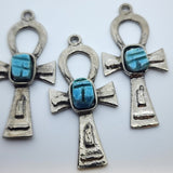 Three Metal Ankh vintage charms with turquoise blue tiny scarab beetle in the centre on a white background