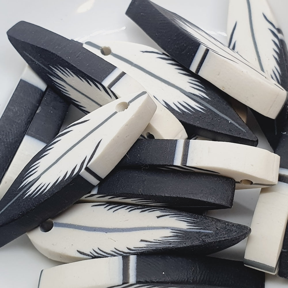 Black and white feather-patterned beads on a white background