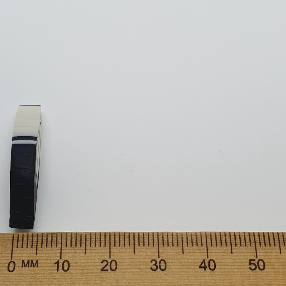 feather bead side on with a ruler for scale on a white background