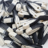 Collection of black and white feather-shaped beads on a white background