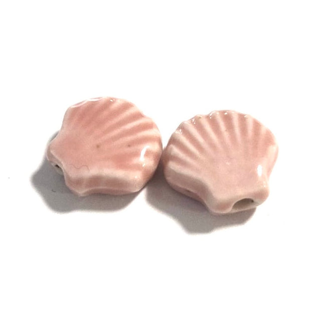 Two pink shell-shaped beads on a white background