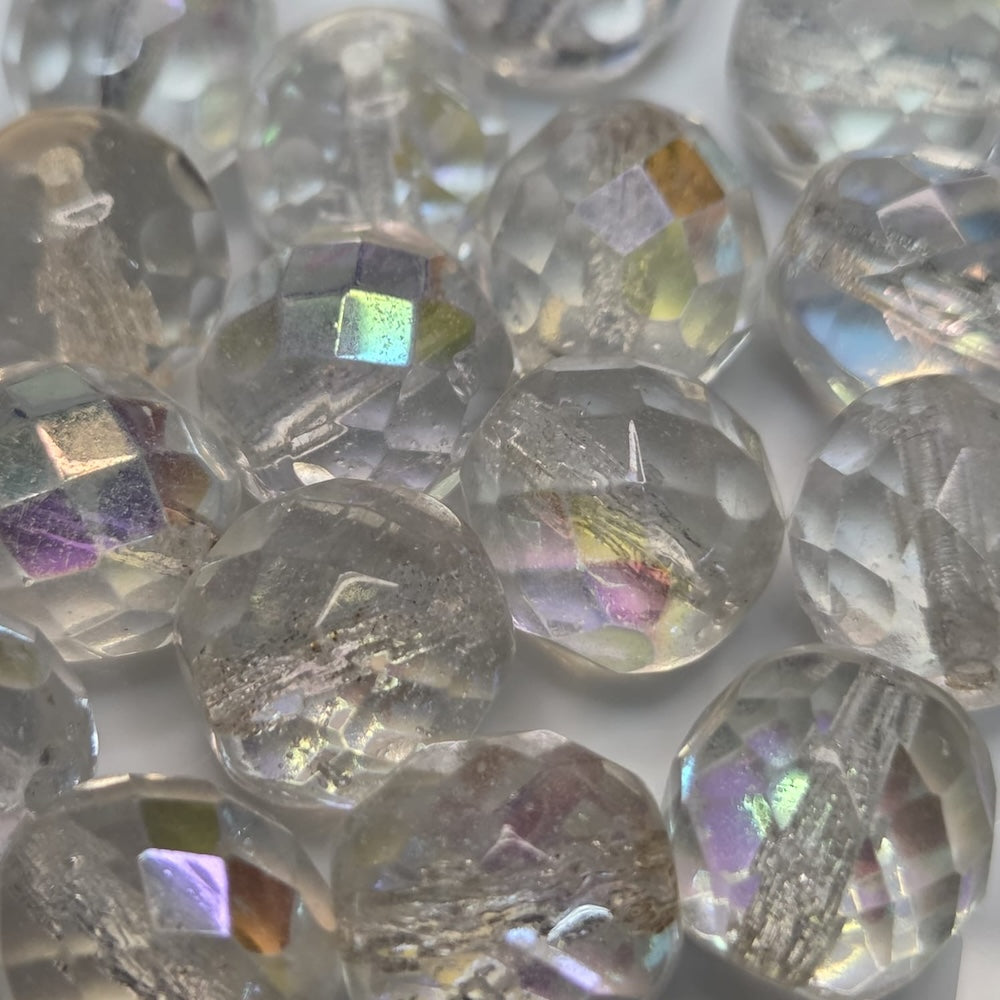 Close-up of clear faceted firepolish beads with iridescent colors on a white background