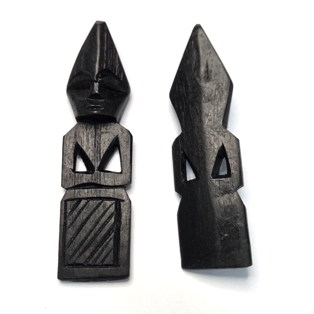 Two black wooden african folk art carvings on a white background