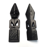 Two black wooden african folk art carvings on a white background
