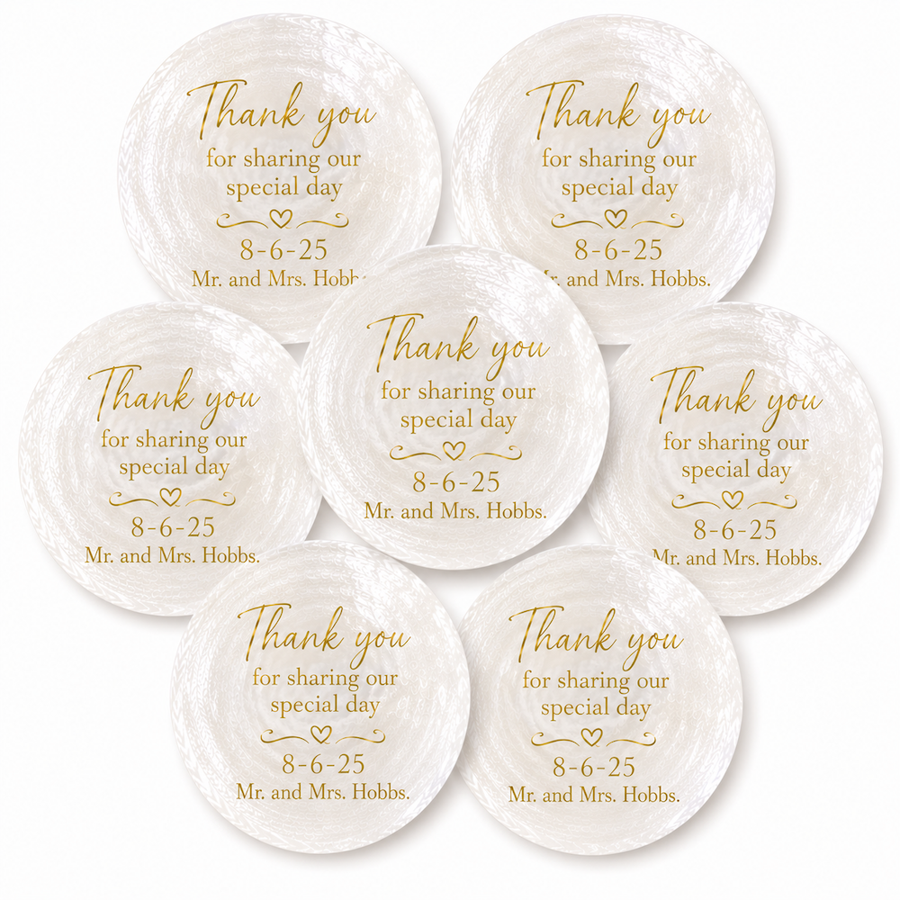 Seven round white shell name place cards with gold engraved text reading 'Thank you for sharing our special day 8-6-25 Mr. and Mrs.
