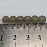 Close-up of translucent grey frosted beads on a white background with a ruler for scale