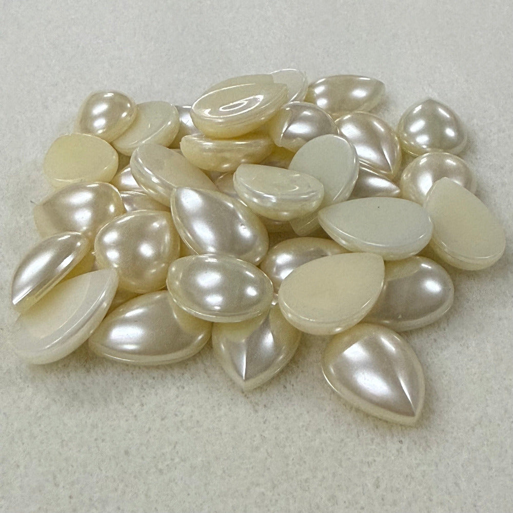 Vintage pearl flat back cabochons on a beige surface
