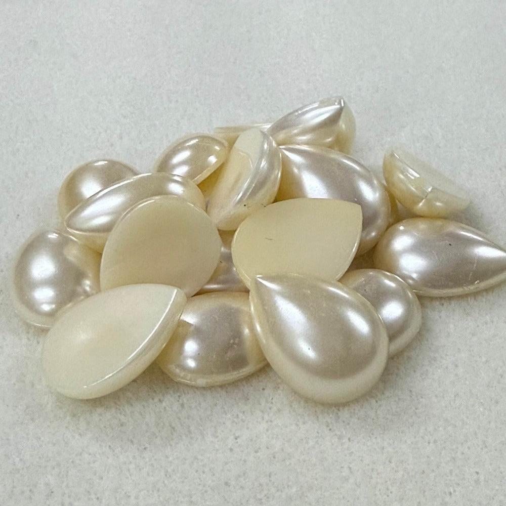 Vintage pearl flat back cabochons on a beige surface