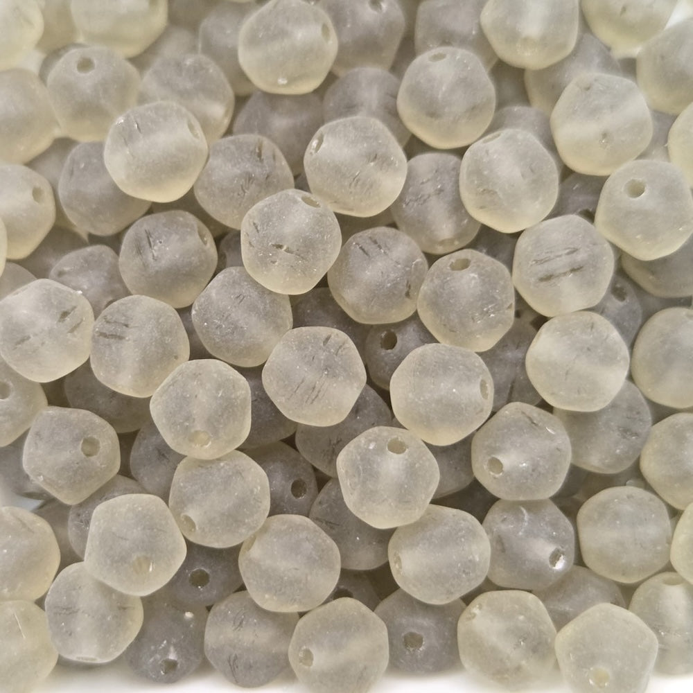 Close-up of translucent grey frosted beads on a white background
