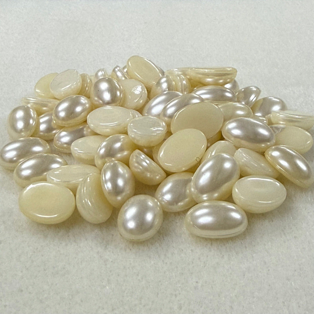 Vintage pearl flat back cabochons on a beige surface