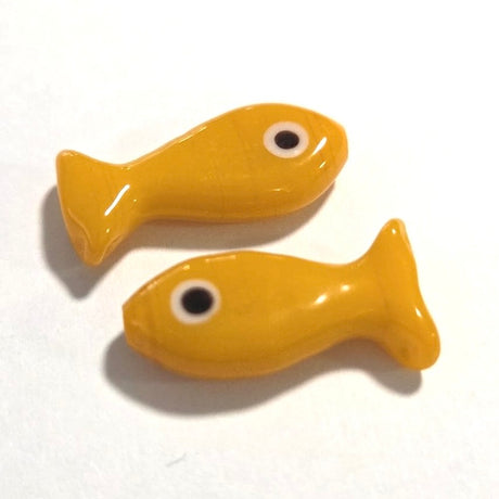 Two orange glass sardine fish on a white background