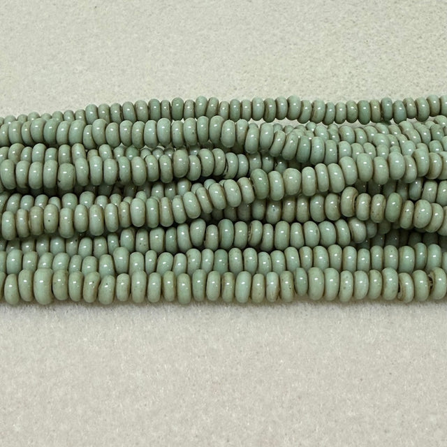 antique green mint donut shaped Indonesian glass bead strands on a white background