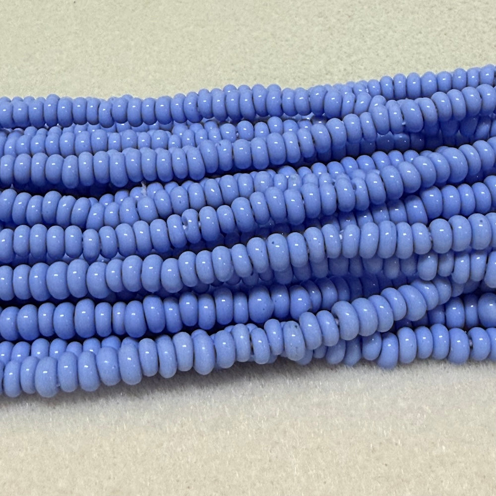 light blue donut shaped Indonesian glass bead strands on a white background