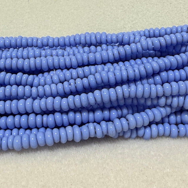light blue donut shaped Indonesian glass bead strands on a white background