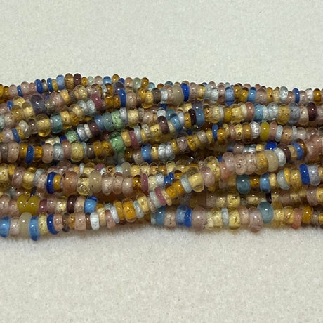 Multicolored donut shaped Indonesian glass bead strands on a white background