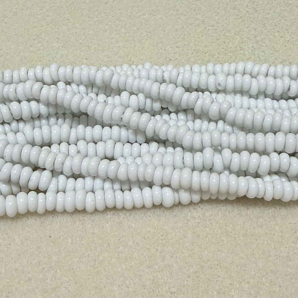 opaque white donut shaped Indonesian glass bead strands on a white background