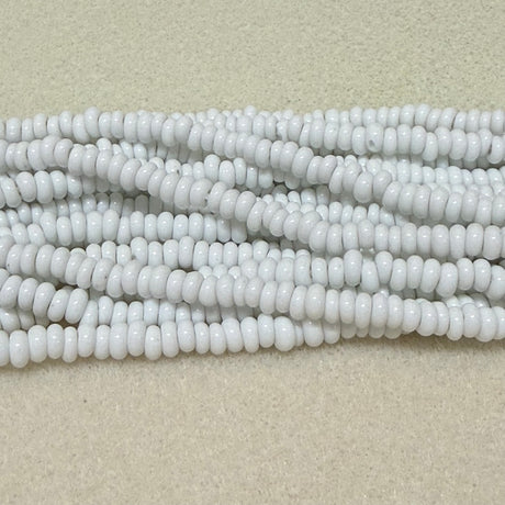 opaque white donut shaped Indonesian glass bead strands on a white background
