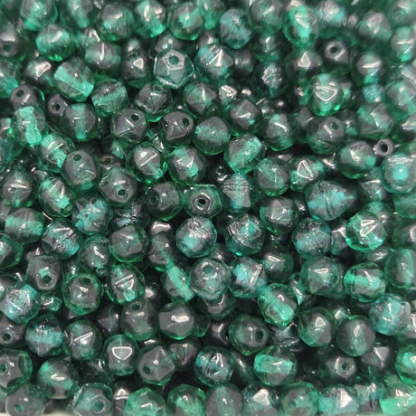 Close-up of green glass beads with a faceted texture.
