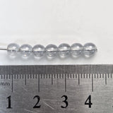 Clear beads on a metal ruler for size reference