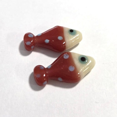 Two ceramic fish-shaped beads with white polka dots on a white background