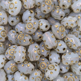 Close-up of white beads with gold patterns